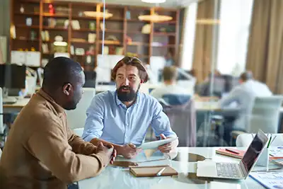 Two men sitting at a table having a discussion.