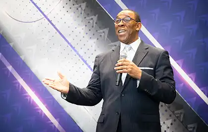 Dennis Daniel speaking on stage.